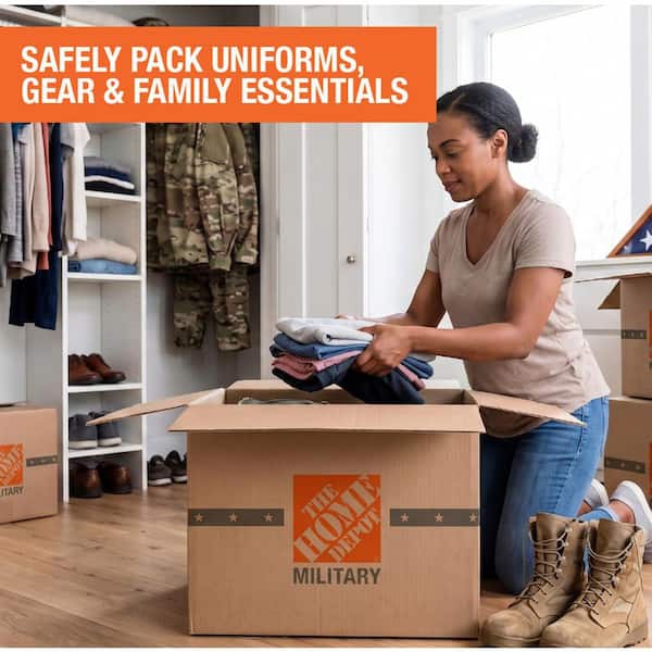 A military family standing in front of a new home with moving boxes