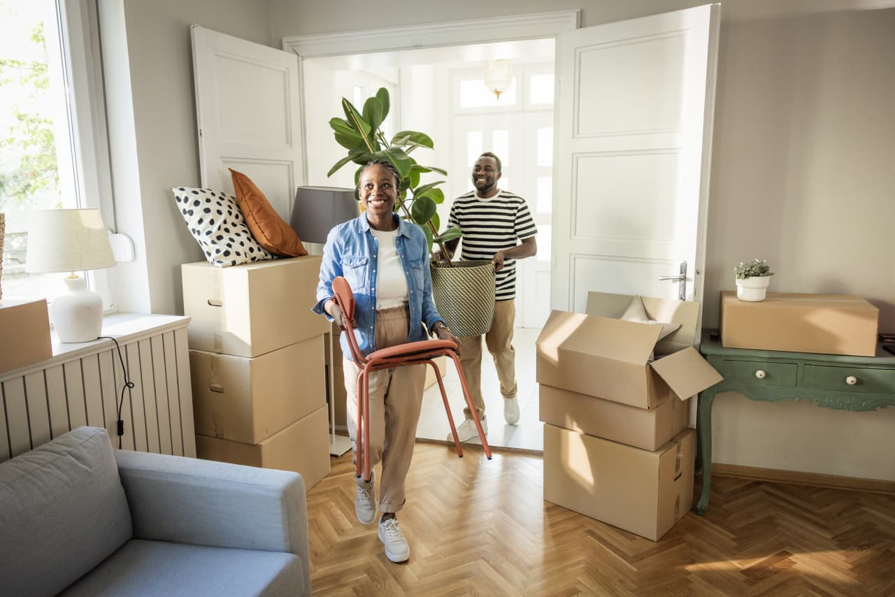 A couple sorting moving boxes, planning their next home purchase