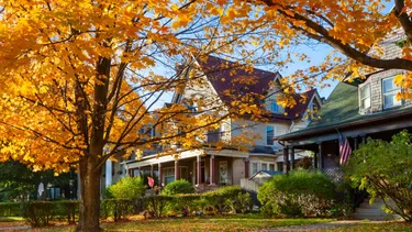 A suburban Houston home with autumn leaves scattered across the front lawn