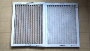A side-by-side comparison of a severely clogged furnace filter next to a clean one