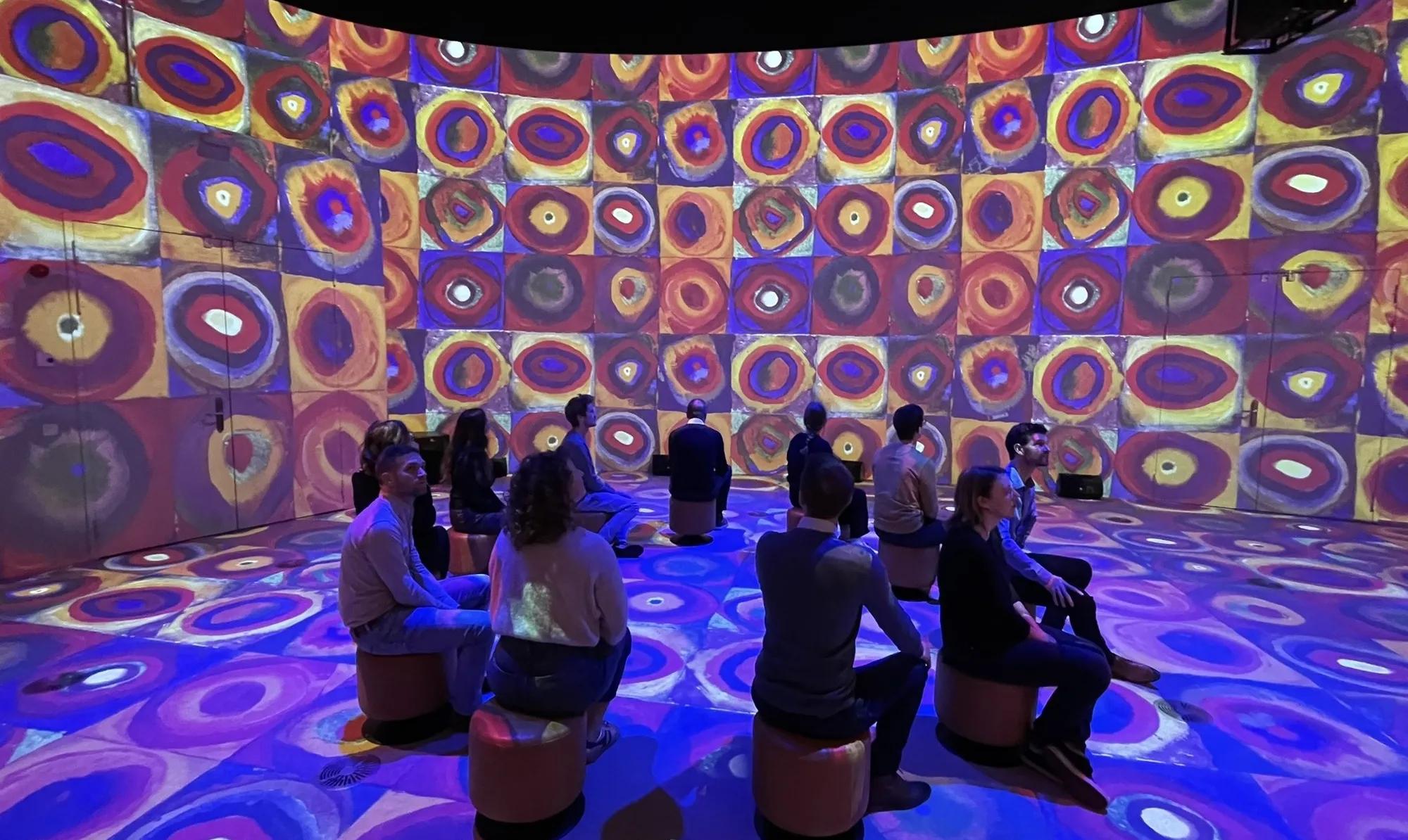 Immersive projection installation filling a dark gallery with light and color