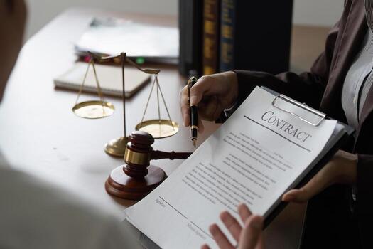 A gavel resting on a dark surface beside a legal document