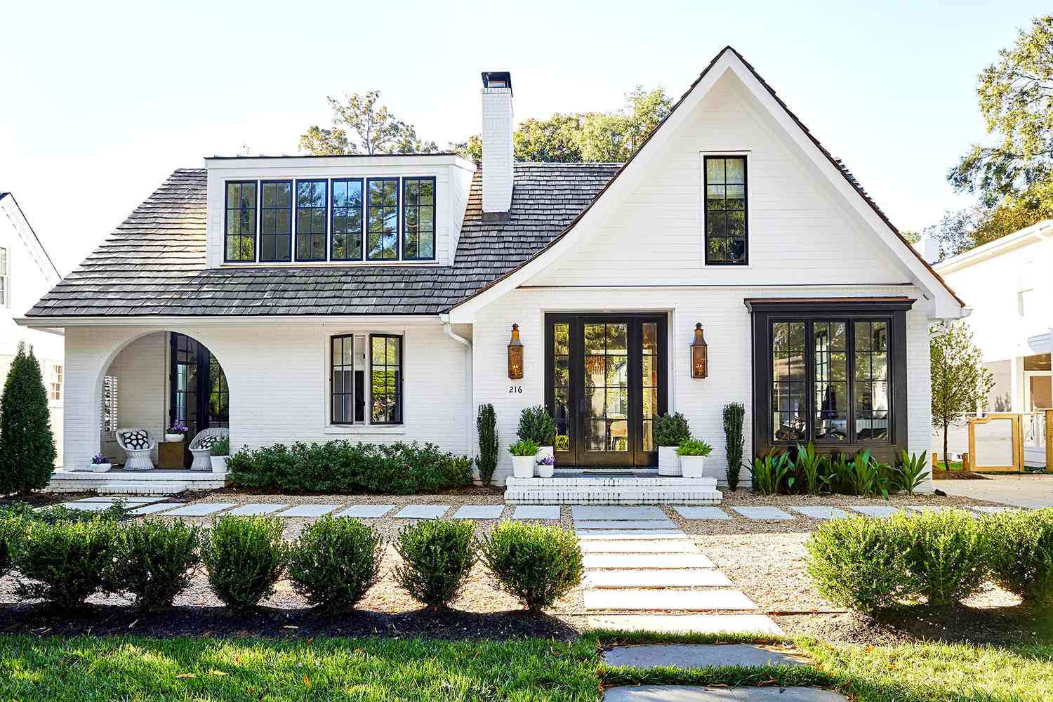 A modern brick home with a welcoming front porch under daylight