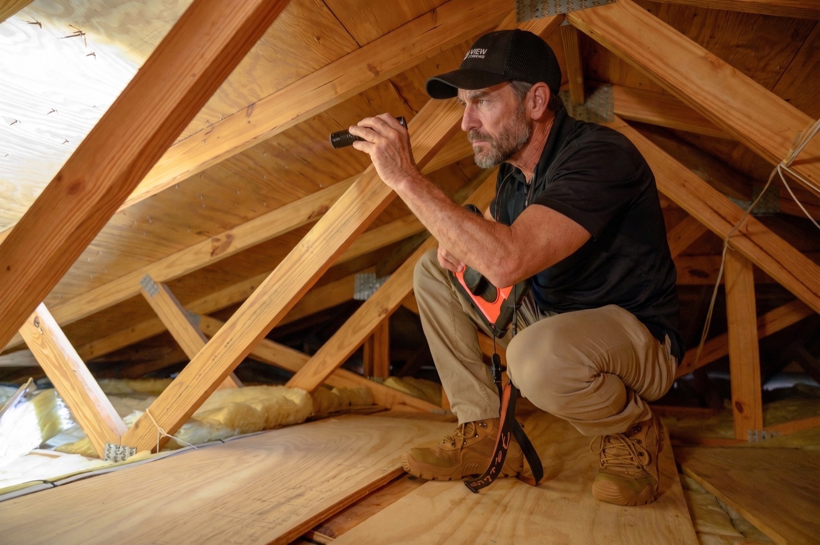 Home inspector using a thermal imaging camera for inspection