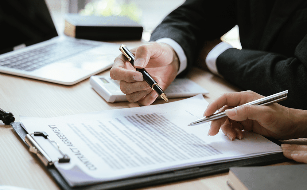 A home buyer and agent signing closing documents at a table