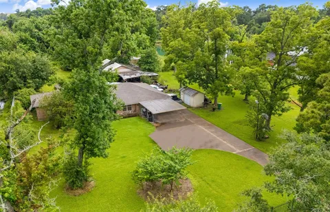 A suburban Houston home listed for sale with a sign in the front yard