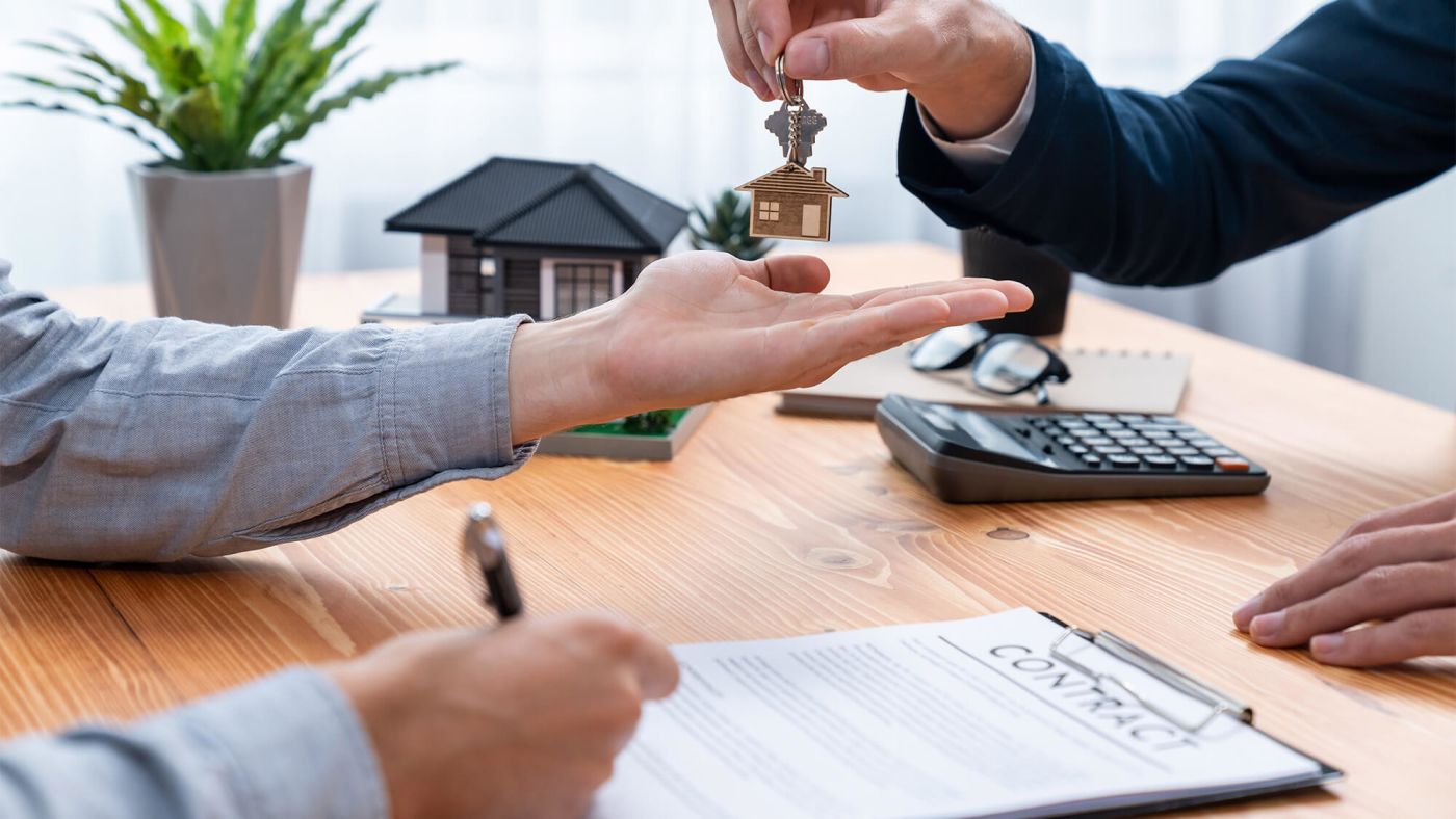 A couple signing a mortgage contract at a closing table