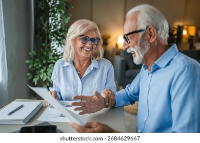 retirement planning couple at kitchen table with financial documents