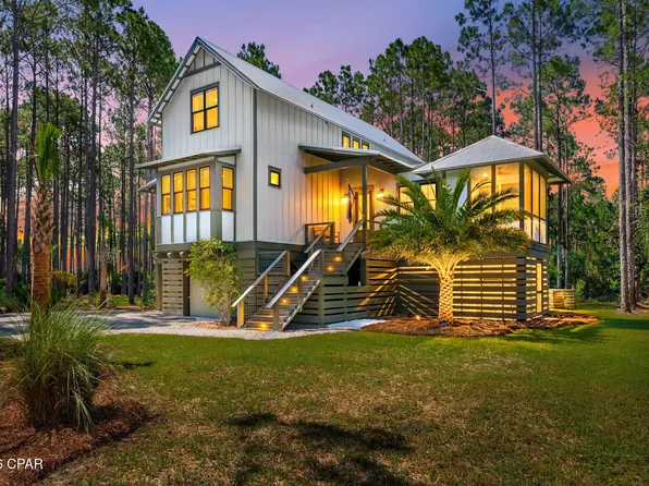 Modern suburban home with for sale sign in morning light