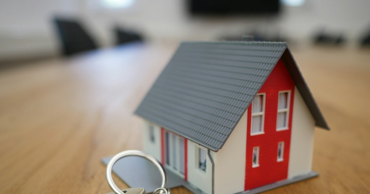 white and red wooden house miniature on brown table