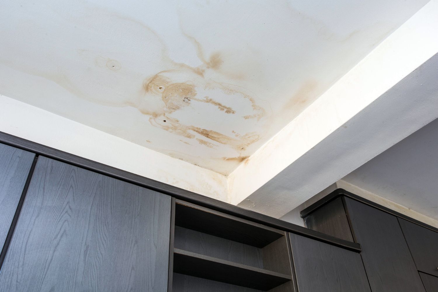 Severe water damage to a ceiling and drywall caused by an undetected leak in a vacant house.